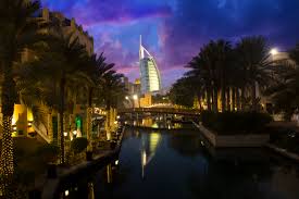 A picture of Dubai UAE at night with palm trees a lake and the burj al arab in the distance - UAE Golden Visa properites